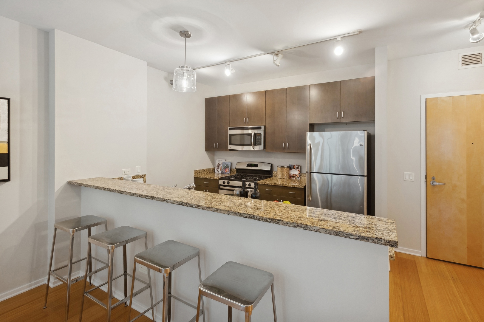 125 South Green Street, Unit 409A Chicago, IL 60607 - Photo 8 of 18 a kitchen with refrigerator and chairs