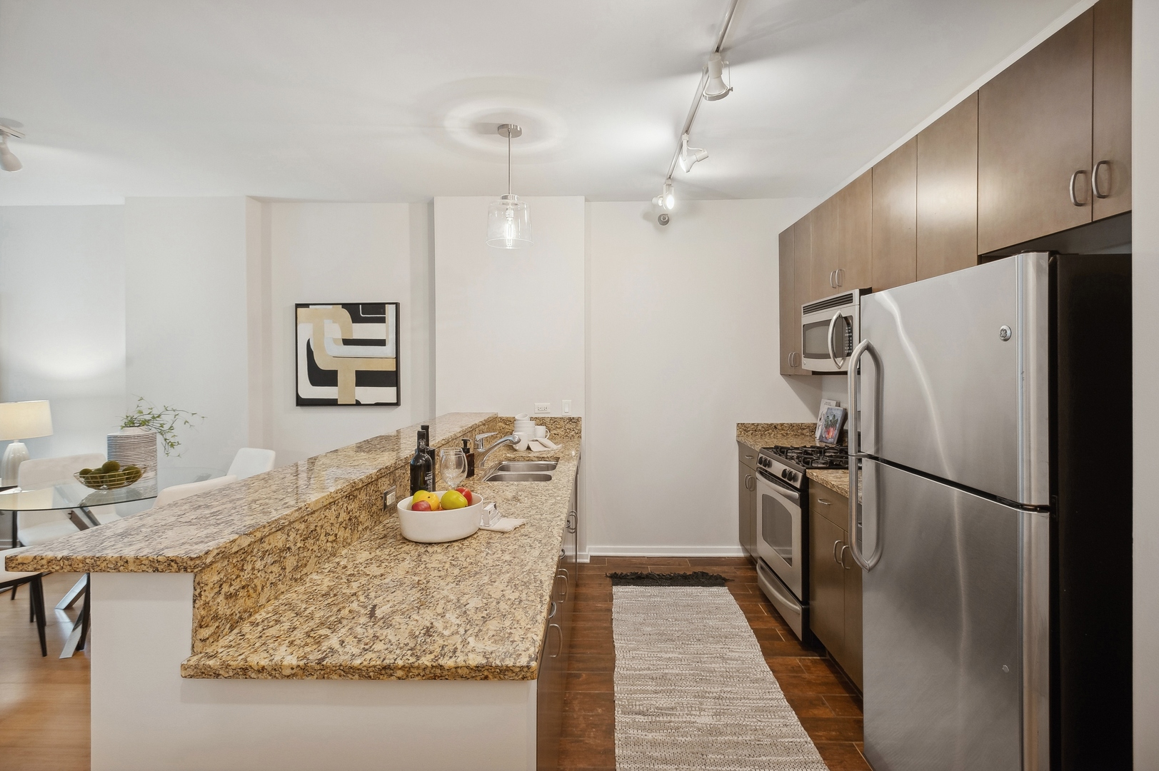 125 South Green Street, Unit 409A Chicago, IL 60607 - Photo 9 of 18 a kitchen with granite countertop refrigerator and microwave