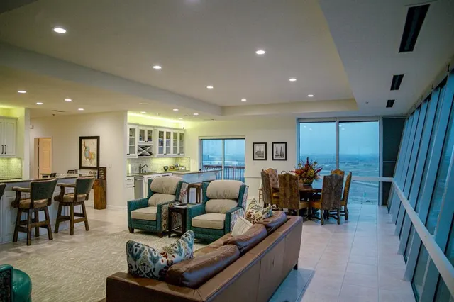 a living room with furniture and a dining table with wooden floor