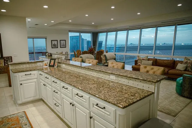 a large kitchen with kitchen island granite countertop a large window