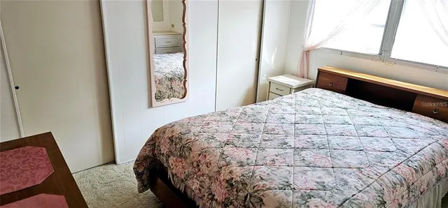 a bedroom with a bed rug and wooden floor
