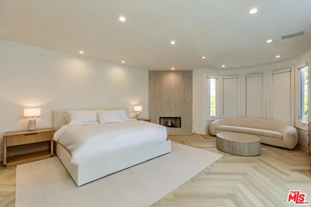 a spacious bedroom with a bed and a large window