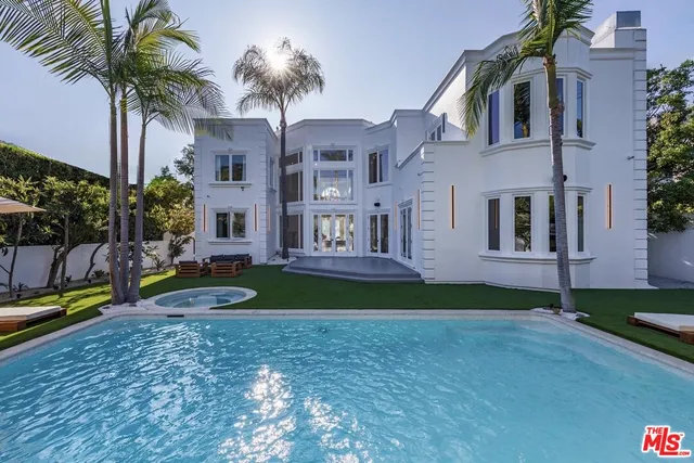 a view of a house with a yard and palm trees