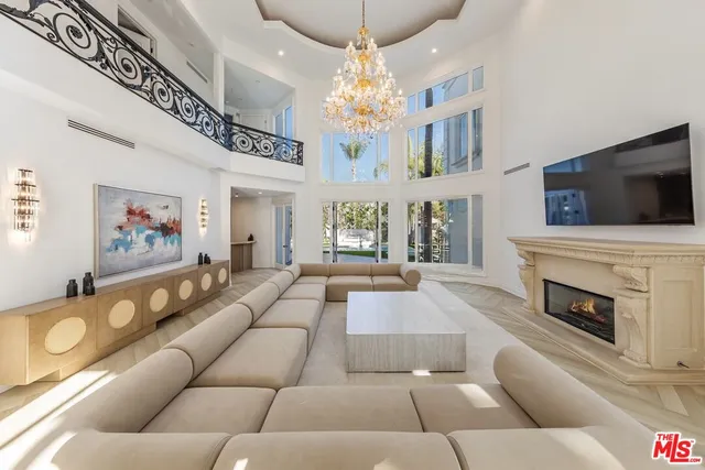 a living room with furniture a fireplace and a chandelier