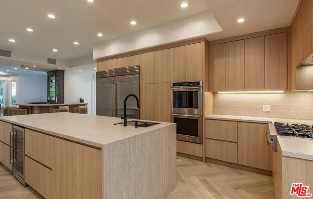 a kitchen with kitchen island a sink stainless steel appliances and counter space