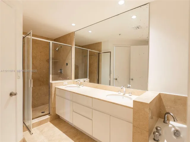 a bathroom with a double vanity sink mirror and shower
