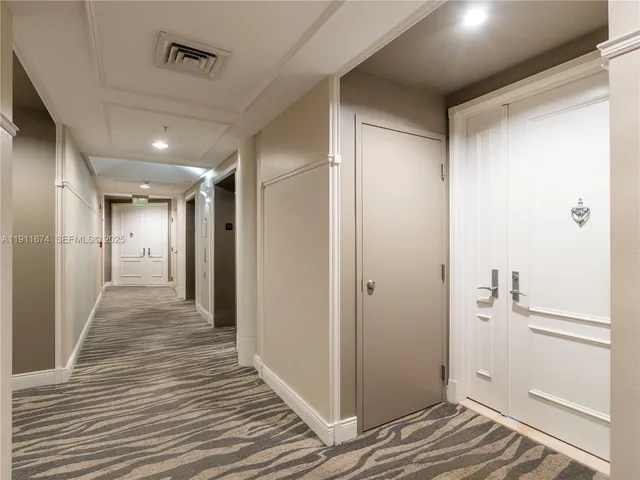 a view of a hallway with wooden floor and closet