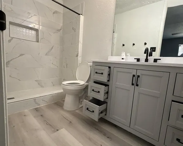 a bathroom with a sink a toilet and shower