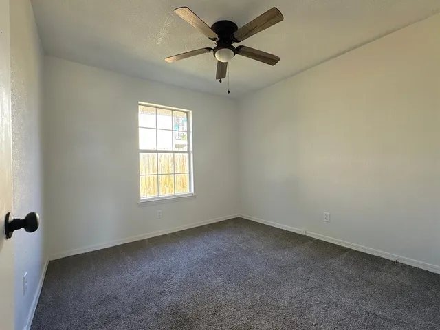 a view of a livingroom with a ceiling fan and window