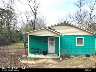 a view of a house with backyard and trees