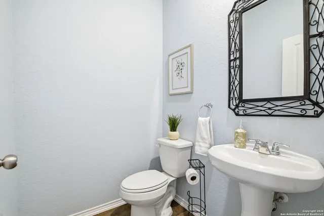 a bathroom with a sink mirror and toilet
