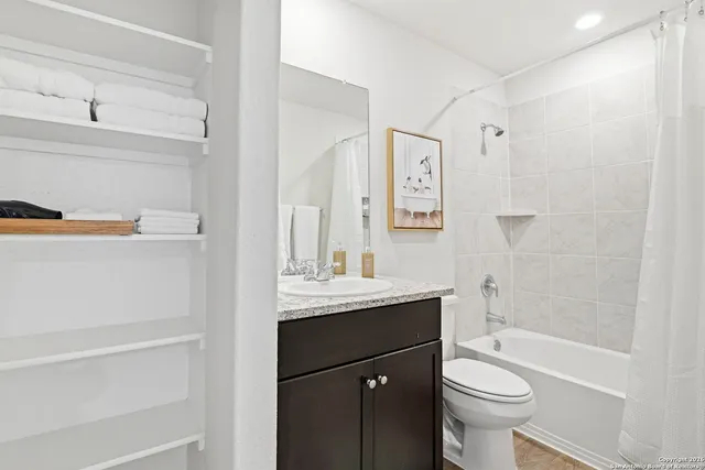 a bathroom with a granite countertop sink toilet and shower