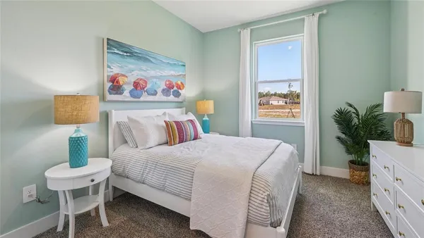 a bedroom with a bed and a potted plant on the dresser