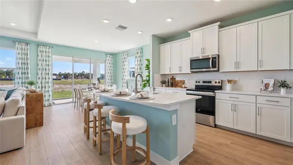 a kitchen with stainless steel appliances granite countertop a stove a sink a microwave a dining table and chairs