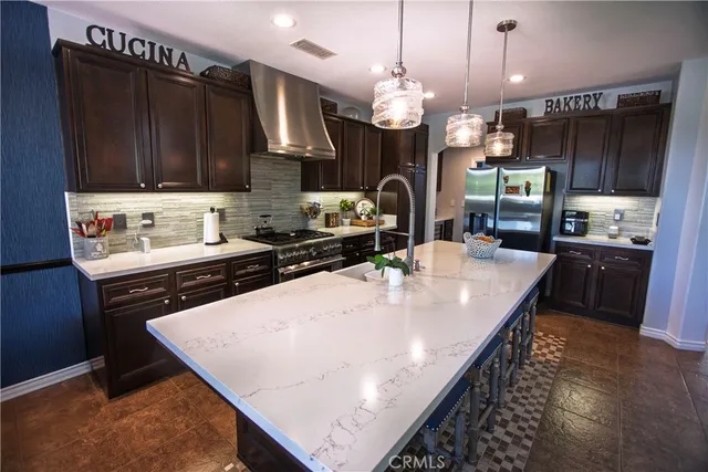 a kitchen with stainless steel appliances granite countertop a sink a stove and a microwave