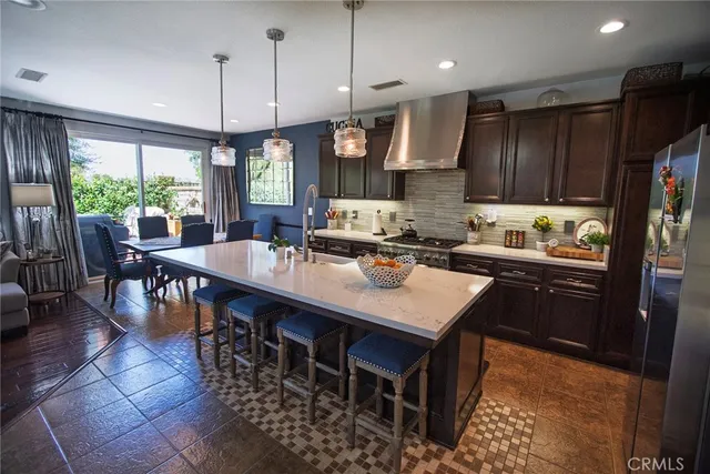 a kitchen with stainless steel appliances granite countertop a sink a stove and a refrigerator