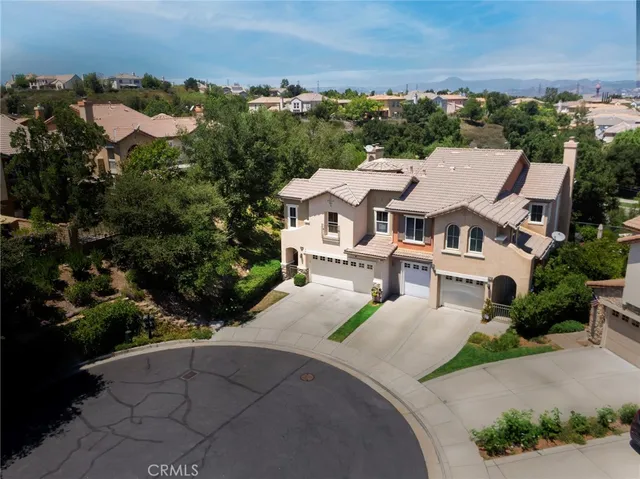 an aerial view of residential houses with outdoor space and trees