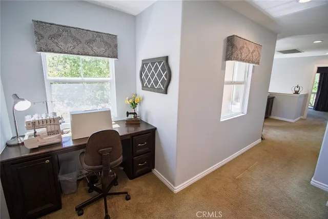 a view of a workspace with furniture and a window