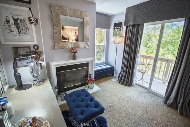 a living room with furniture a fireplace and a large window