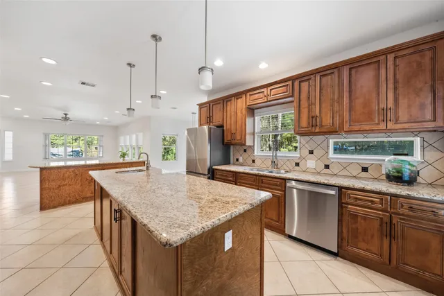 a kitchen with granite countertop a sink stainless steel appliances and cabinets