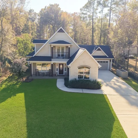 an aerial view of a house with a yard and lake view