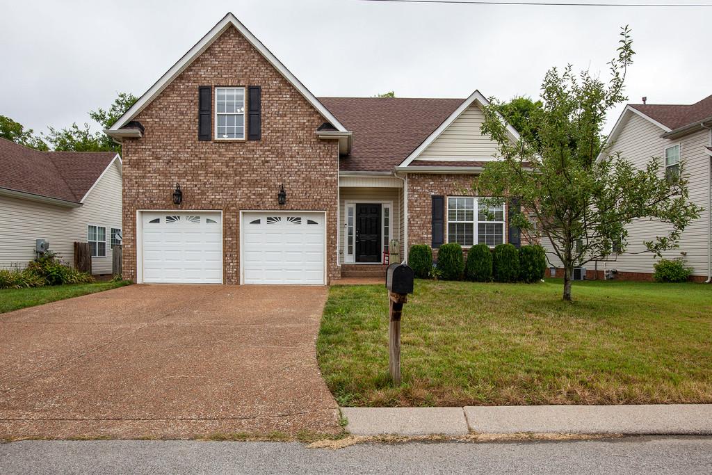 1038 Golf View Way Spring Hill, TN 37174 - Photo 1 of 16 a front view of a house with a yard and garage