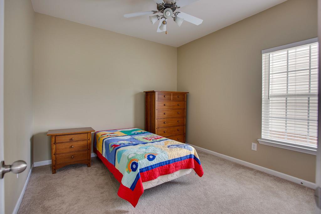 1038 Golf View Way Spring Hill, TN 37174 - Photo 12 of 16 a bedroom with a bed and a chandelier