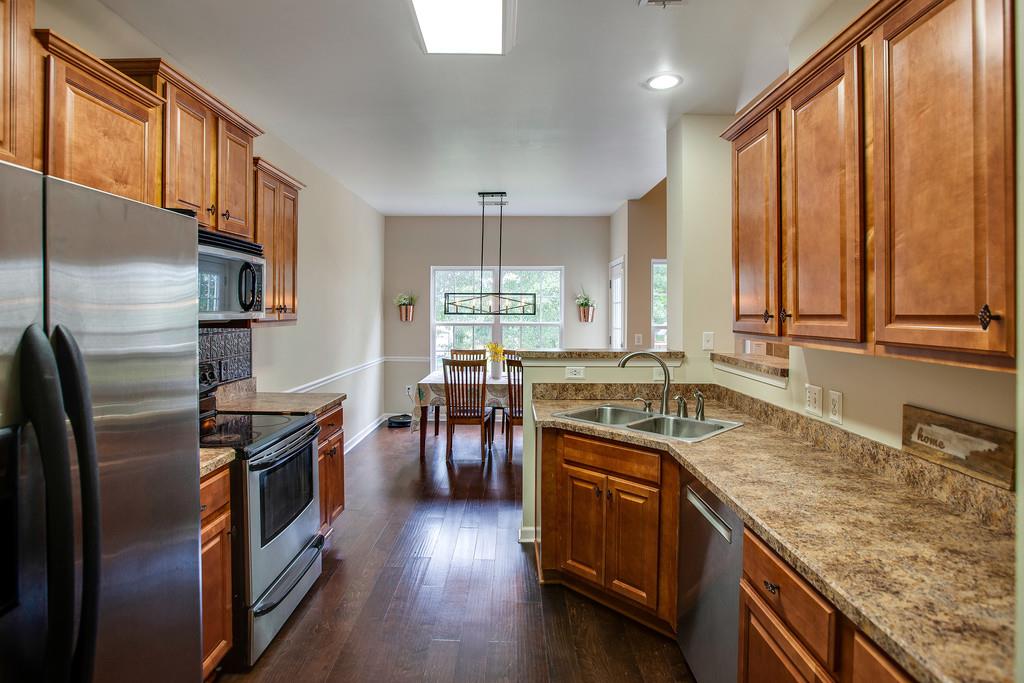 1038 Golf View Way Spring Hill, TN 37174 - Photo 7 of 16 a kitchen with stainless steel appliances granite countertop a sink stove and refrigerator