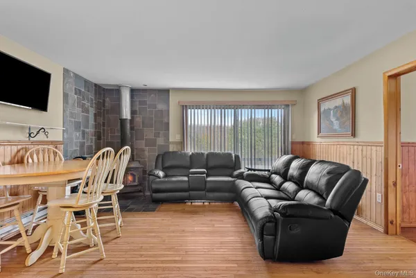 a living room with furniture a flat screen tv and wooden floor
