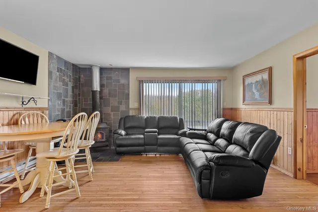 a living room with furniture a flat screen tv and wooden floor