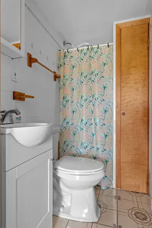 a white toilet sitting next to a bathroom sink