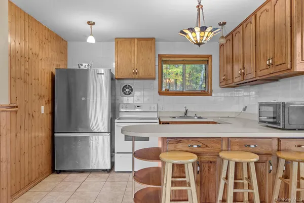 a kitchen with stainless steel appliances granite countertop a refrigerator a sink dishwasher a dining table and chairs with wooden floor