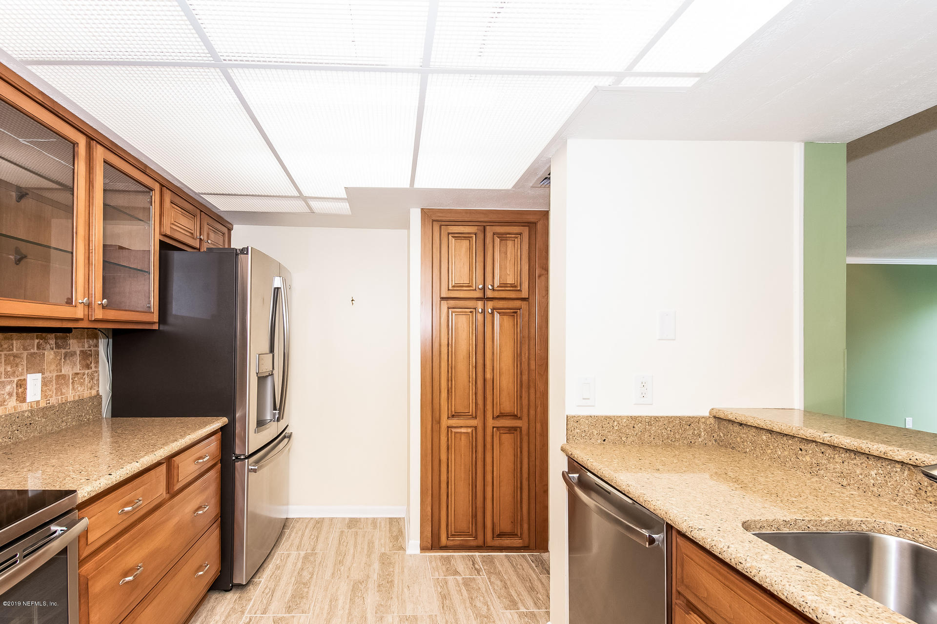 5478 Stanford Road Jacksonville, FL 32207 - Photo 3 of 26 a kitchen with granite countertop a sink and refrigerator