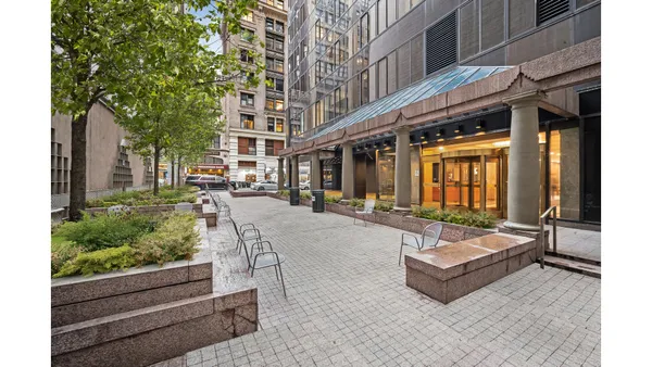 a building outdoor space with patio furniture and potted plants