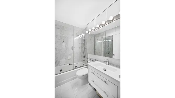 a bathroom with a tub shower sink and mirror