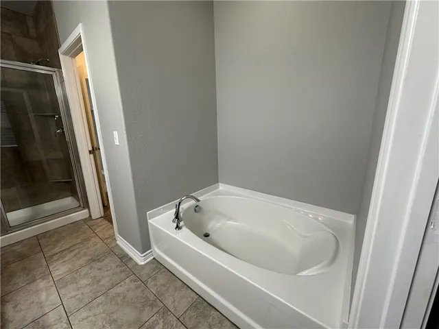 a white bath tub sitting next to a white sink and vanity