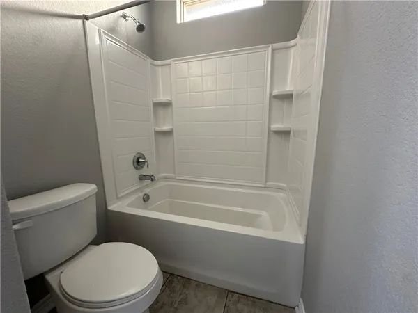a white toilet and tub sitting next to a bathroom sink
