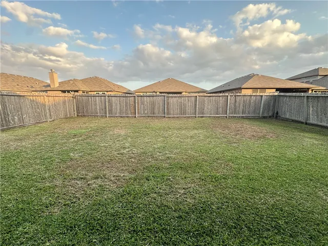 a view of a yard with wooden fence