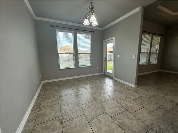 an empty room with chandelier and windows
