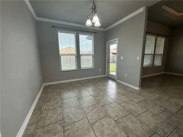 an empty room with chandelier and windows