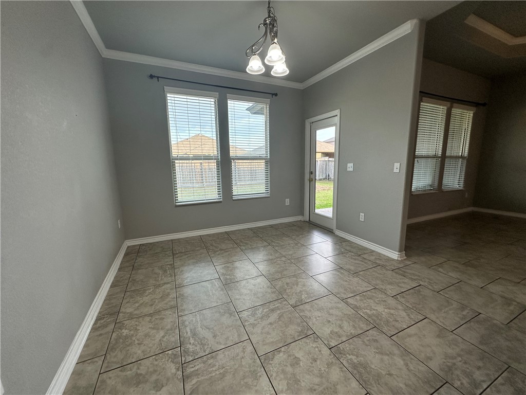 1015 Santa Catalina Street Portland, TX 78374 - Photo 7 of 34 an empty room with chandelier and windows