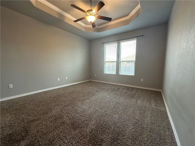 en empty room with windows and ceiling fan