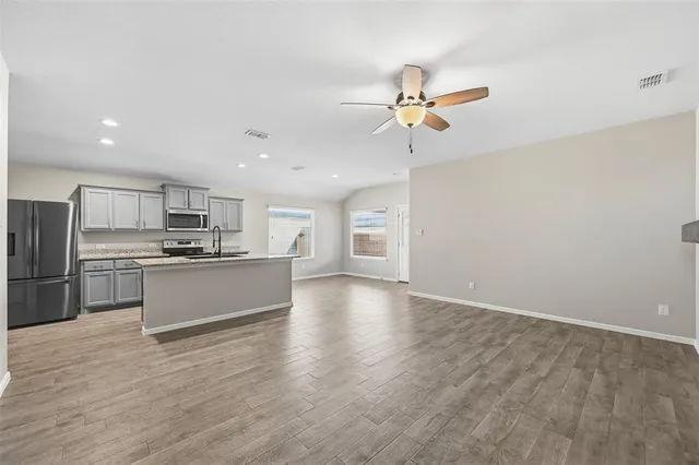a view of kitchen with refrigerator microwave and stove