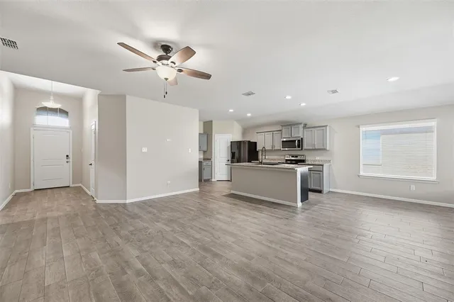 a view of kitchen with cabinets stainless steel appliances and a window