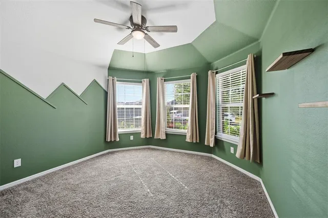 an empty room with windows and ceiling fan