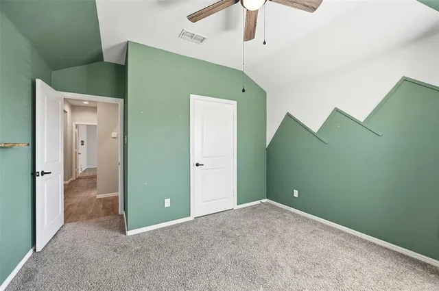 an empty room with closet and a chandelier fan