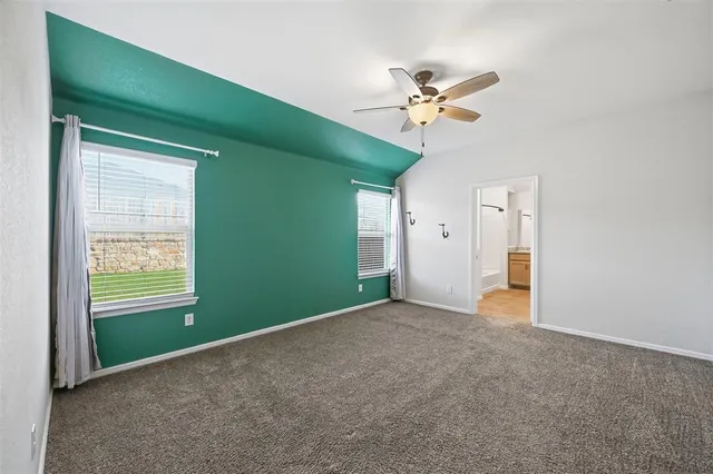 a view of an empty room with window and closet area