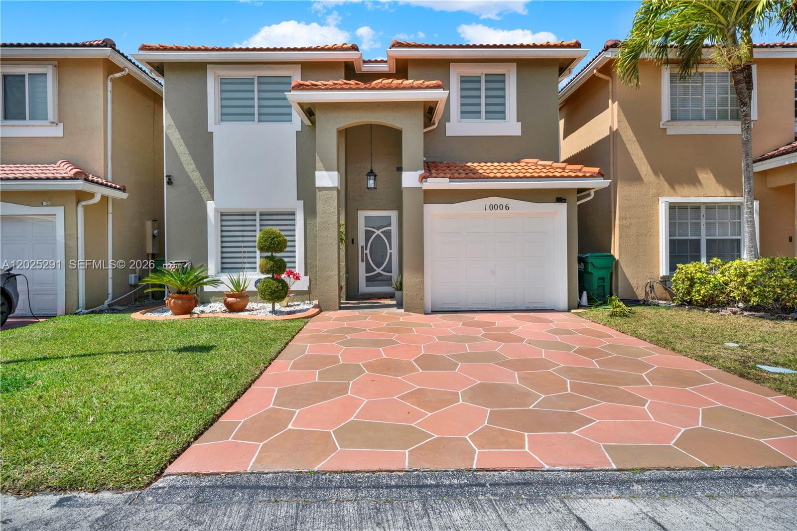 10006 Southwest 162nd Path Miami, FL 33196 - Photo 1 of 40 a front view of a house with garden