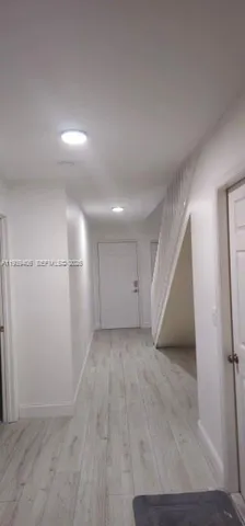 an empty room with staircase and white walls