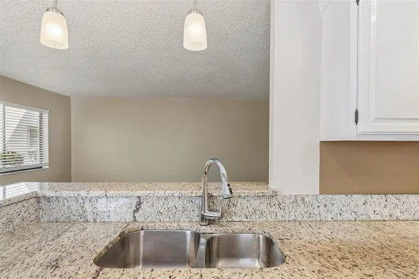 a bathroom with a granite countertop sink toilet and mirror